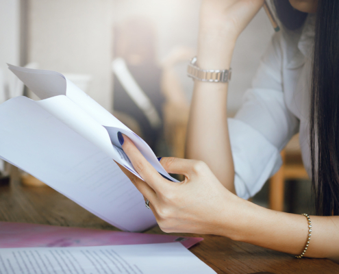 Young woman thinking and read information from paper in hand