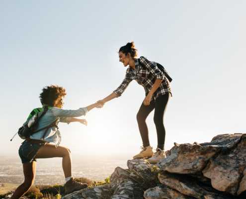 Person helping companion on hike